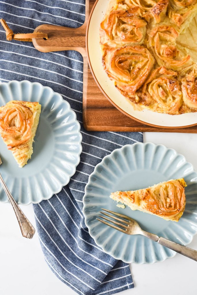 Greek ruffled pie slices on two plates beside platter