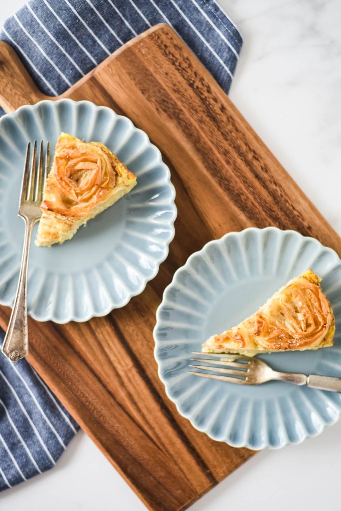 two slices of greek ruffle pie on blue plates on wood board