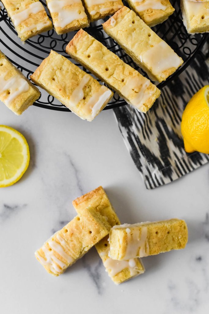 lemon shortbread cookies on counter with slices of lemon