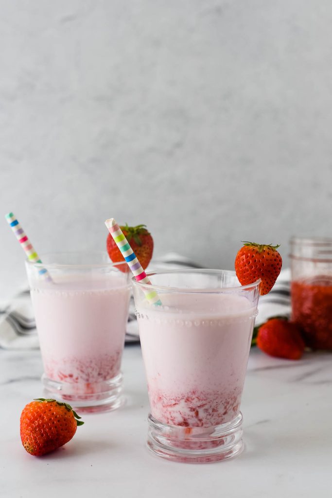 strawberry milk in two glasses with pink striped straws