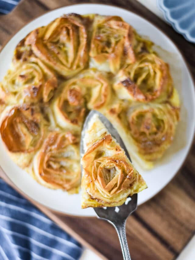 hand pulling slice of greek ruffled pit out of whole