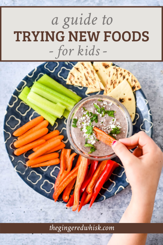 kids hand dipping veggies into dip