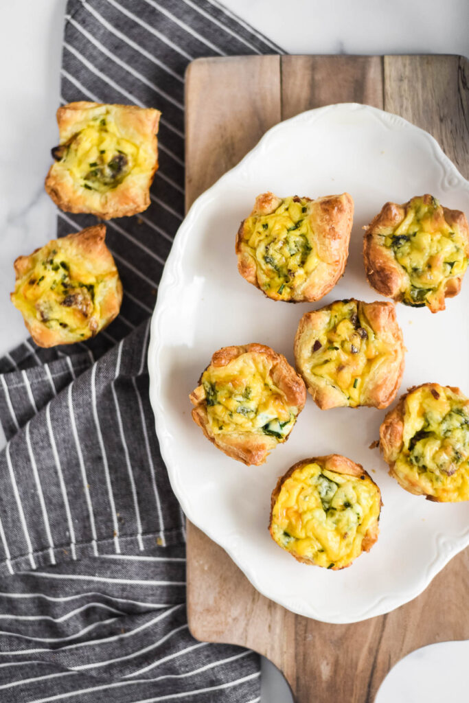 puff pastry quiches on platter sitting on wooden tray