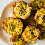 mini quiches with bacon piled on white platter