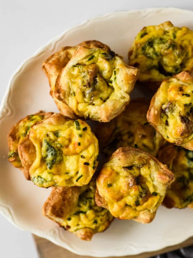 mini quiches with bacon piled on white platter