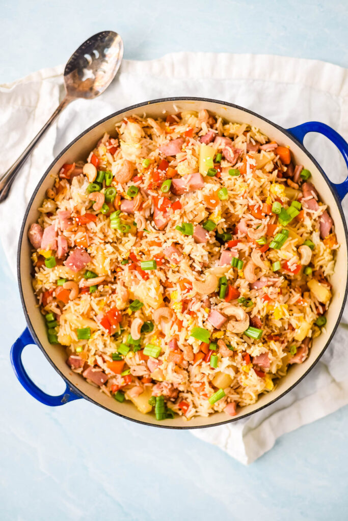 blue pan filled with ham and pineapple fried rice