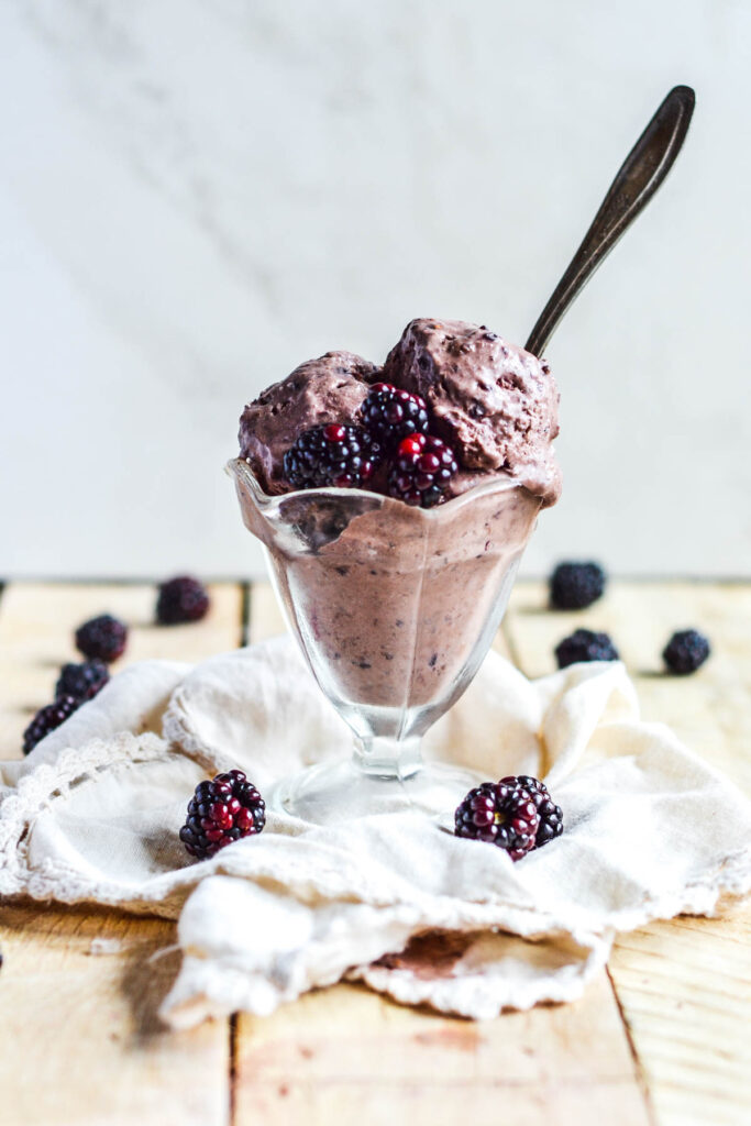 ice cream dish on napkin with blackberries around 