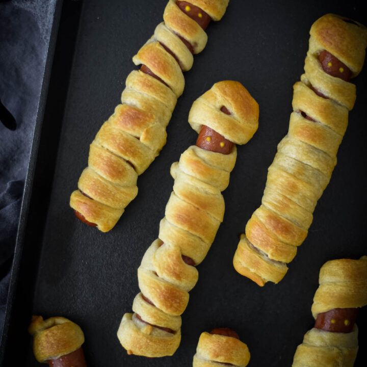 mummy hot dogs on black tray