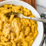 pasta in pumpkin sauce on white bowl with fork