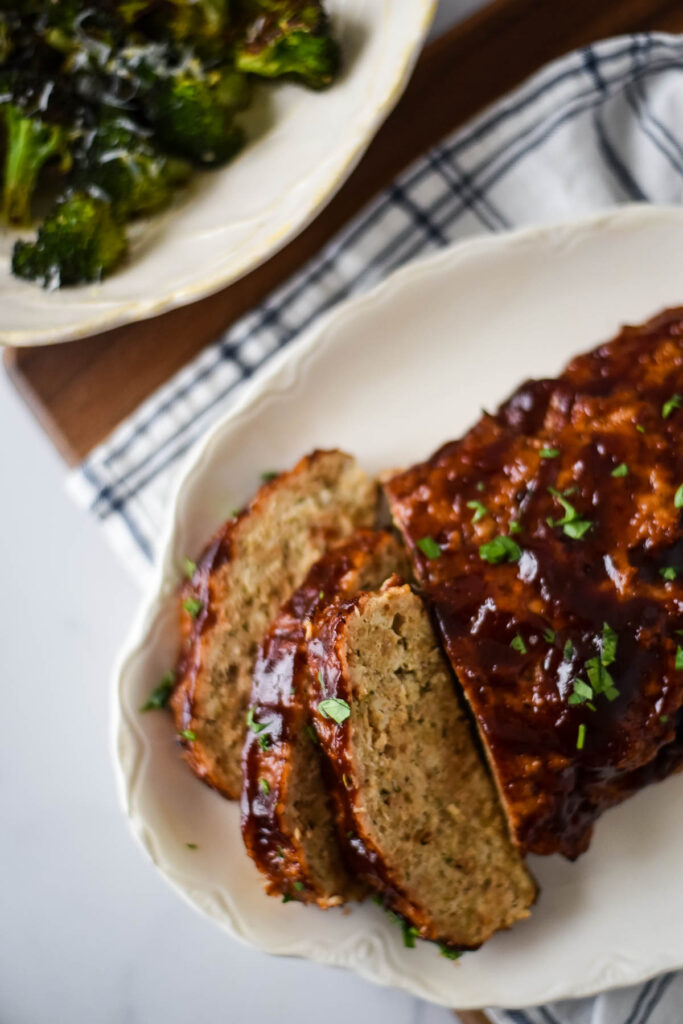 chicken meatloaf with bbq sauce with bowl of broccoli beside it