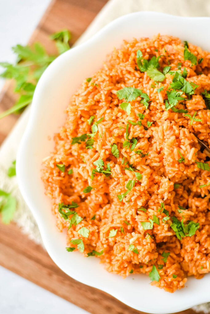 closeup of rice with seasoning and tomato sauce sprinkled with cilantro