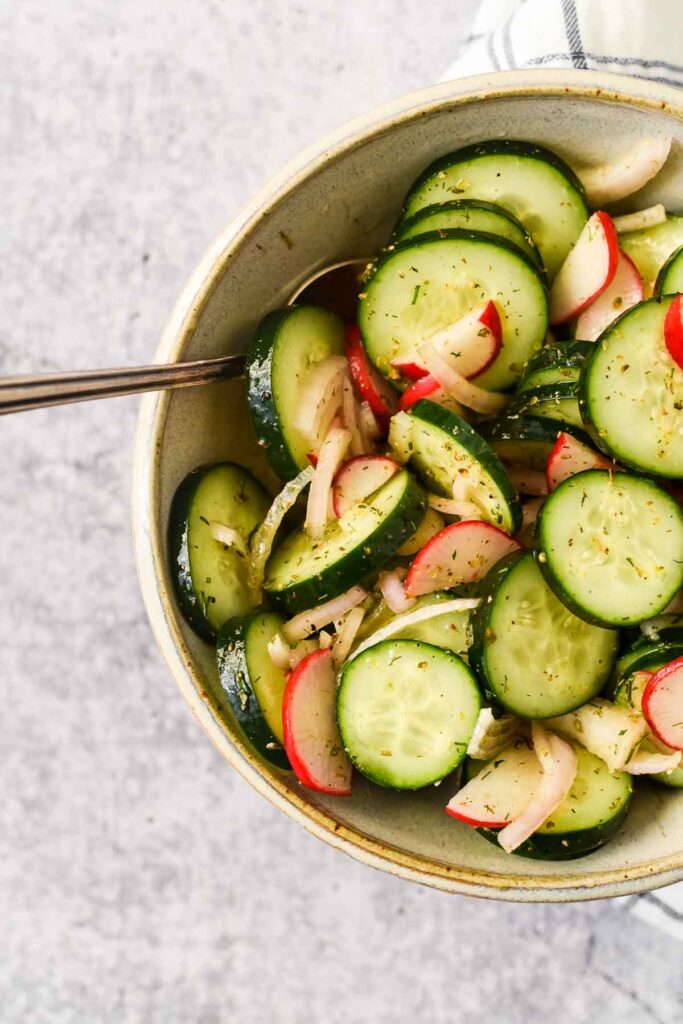 Mediterranean Cucumber Salad in grey bowl with serving spoon