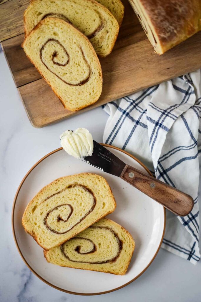 cinnamon swirl bread slice on plate with butter and knife