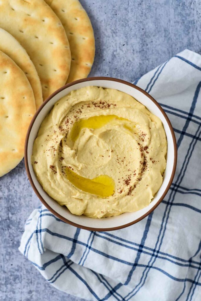bowl of hummus with olive oil and paprika sprinkled on top