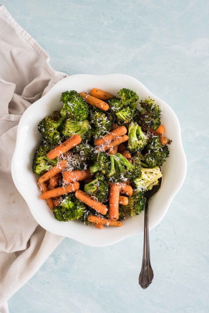 broccoli and carrots with italian seasoning and parmesan cheese in white bowl