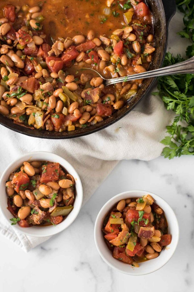 charro beans in two small bowls next to cast iron skillet with more