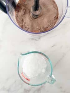 adding crushed ice to blender with cocoa powder and milk