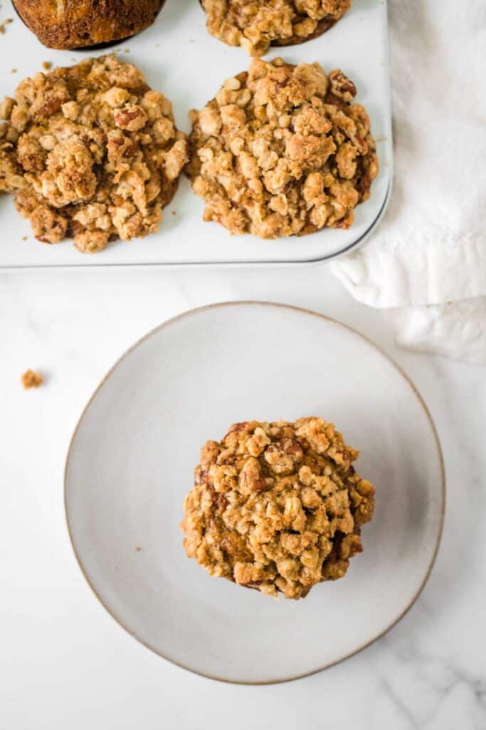 banana carrot muffin on plate next to muffin pan