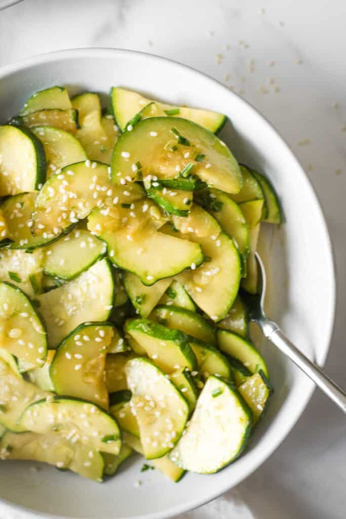 close up of korean zucchini recipe in white bowl with serving spoon
