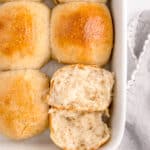 baking dish with sourdough dinner rolls, and roll in corner cut in half