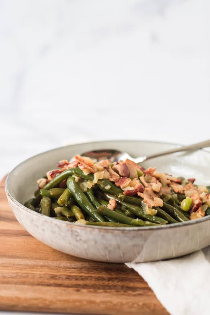 side view of green beans with bacon in serving dish