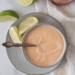 bowl of spicy mayo with spoon and lime wedges