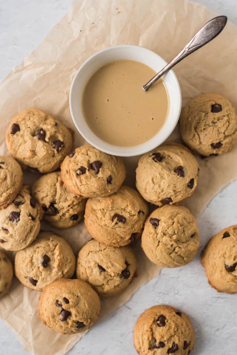 chocolate chip cookies on baking paper next to bowl of tahini
