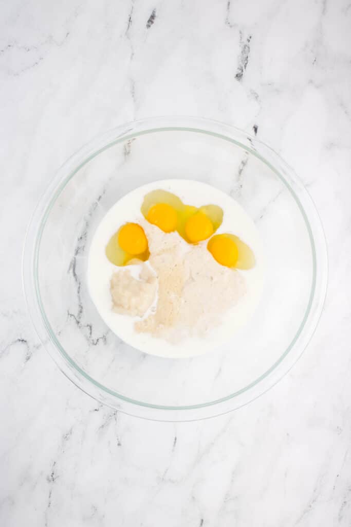 bowl with milk, eggs, and sourdough starter