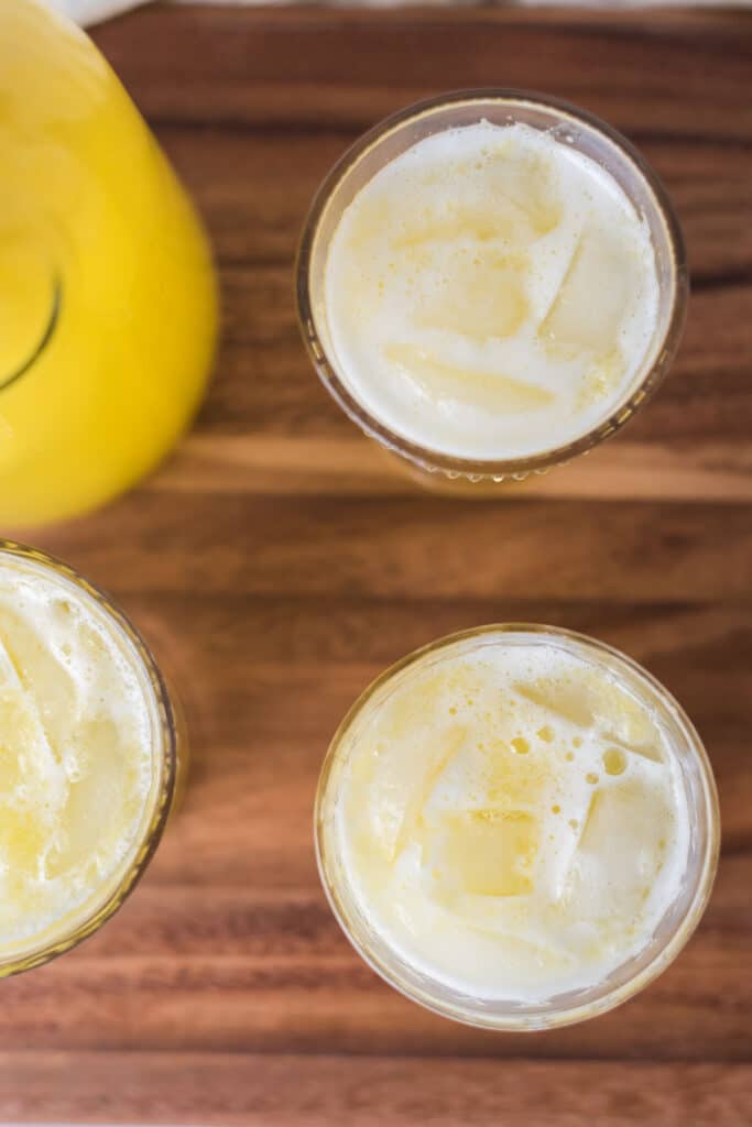 overhead view of glasses filled with pineapple juice and ice