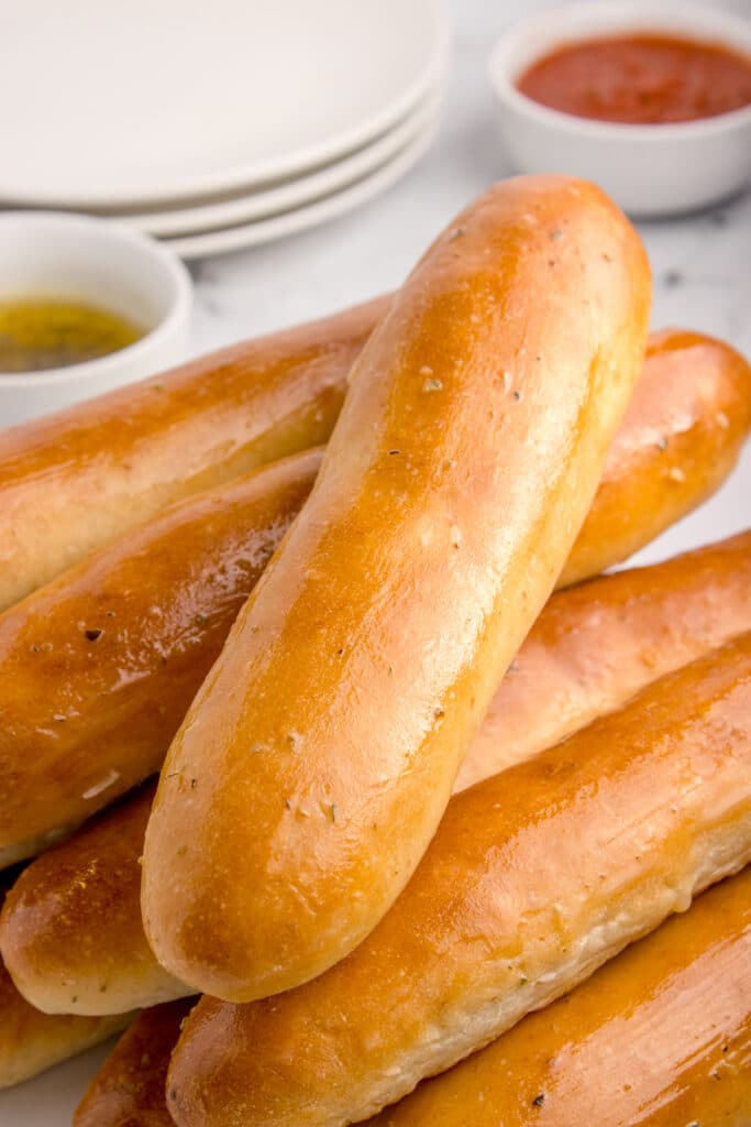sourdough breadsticks piled on top of each other with top one at an angle