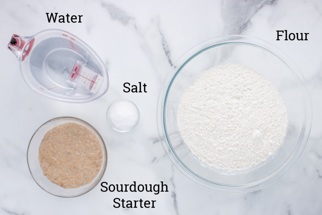 ingredients for sourdough bread bowls on marble counter with text labels