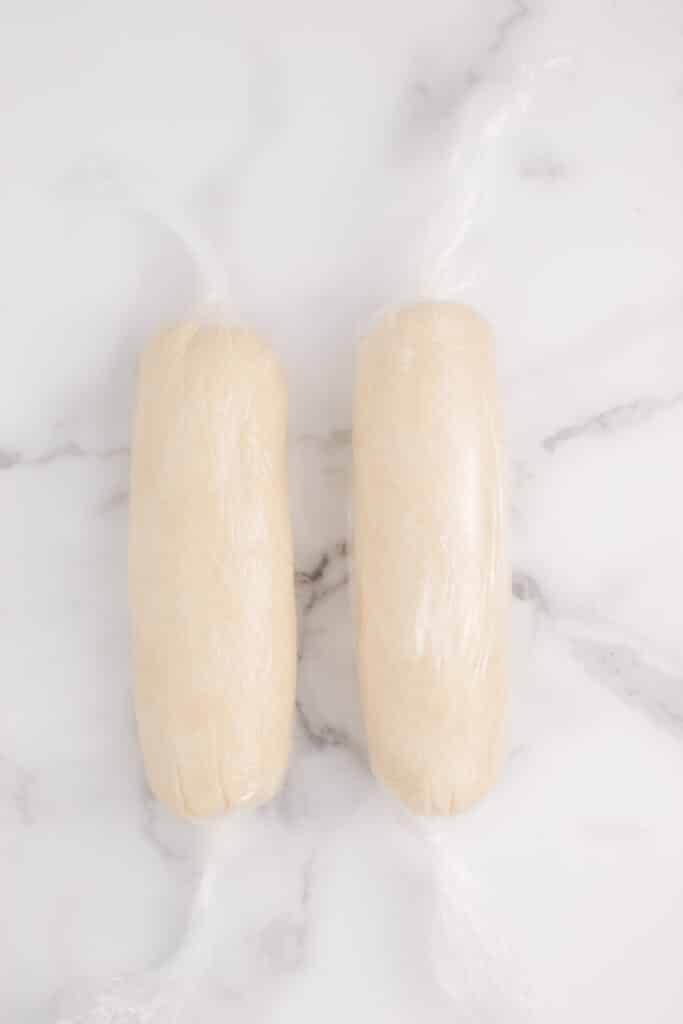 shortbread cookie dough wrapped in plastic wrap logs