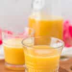 two small glasses filled with pot juice in front of pitcher