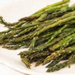 closeup of roasted asparagus on white platter
