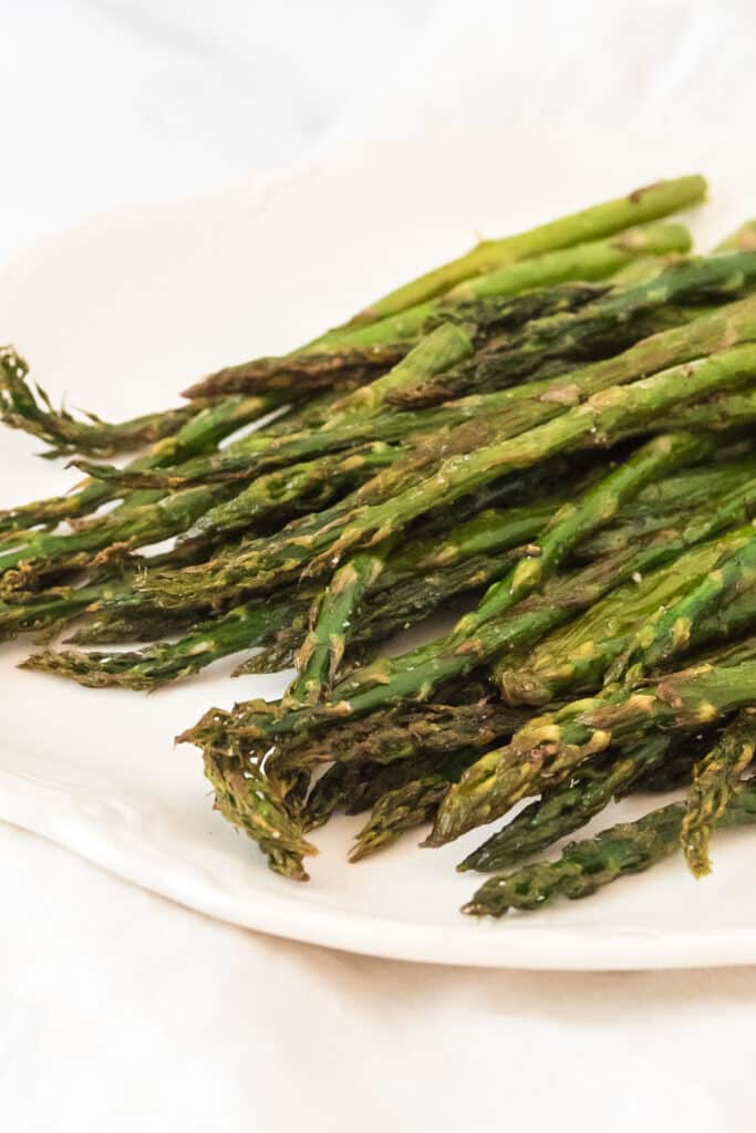 closeup of roasted asparagus on white platter