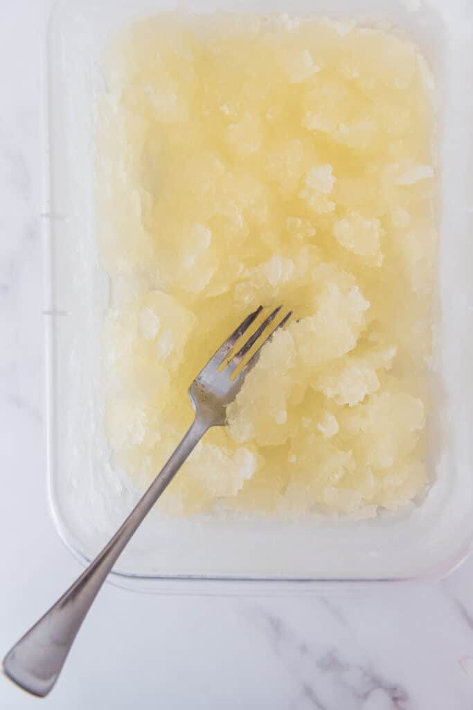 container with fork scraping semi-frozen lemon granita mixture