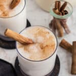 horchata in glasses with cinnamon sticks as garnish and more beside