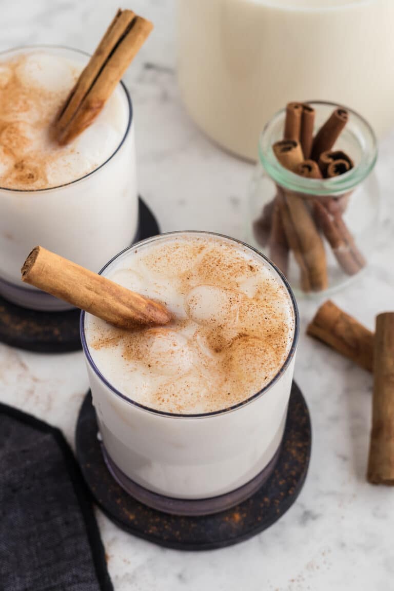 horchata in glasses with cinnamon sticks as garnish and more beside