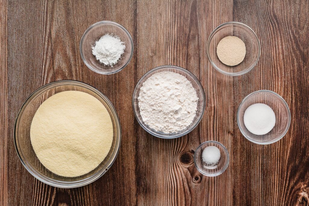 ingredients for million hole pancakes in glass bowls on wooden table