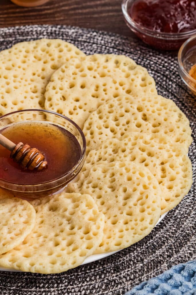 platter with Moroccan pancakes arranged around small bowl of honey
