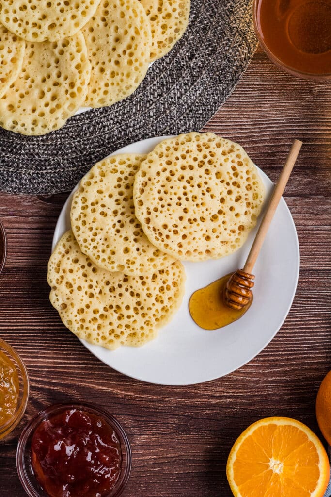 million dollar pancakes on plate with honey with jar of jam beside