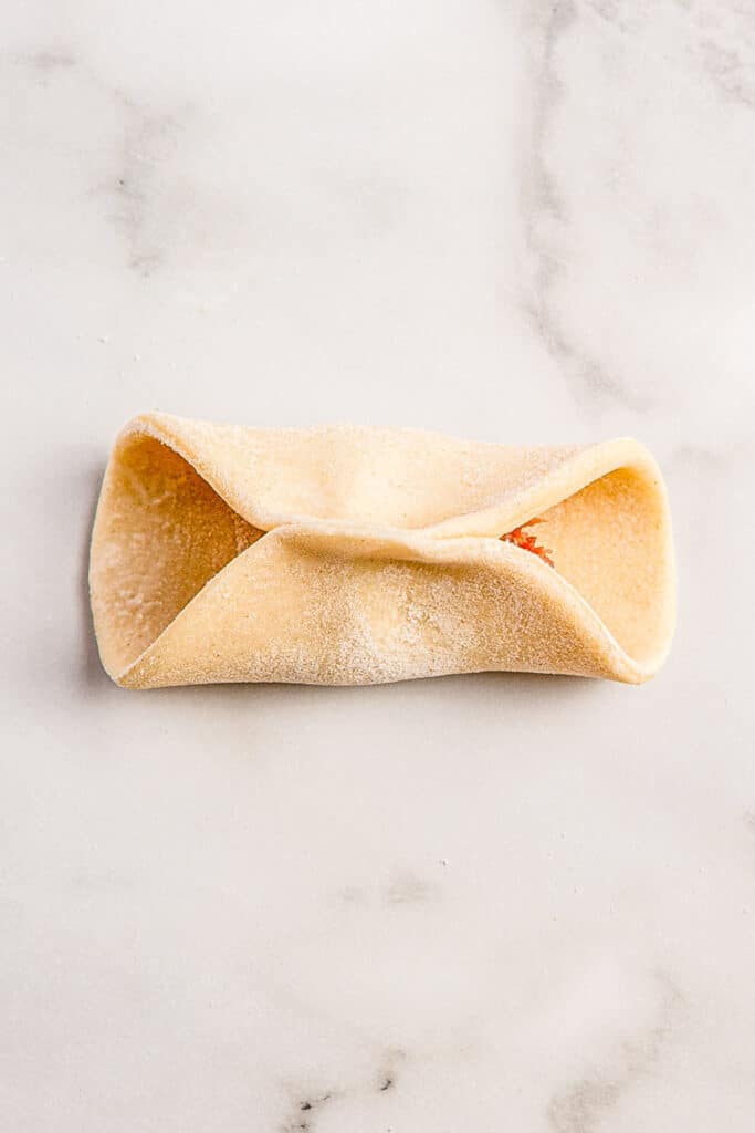 dumpling being pinched in center of circle of dough