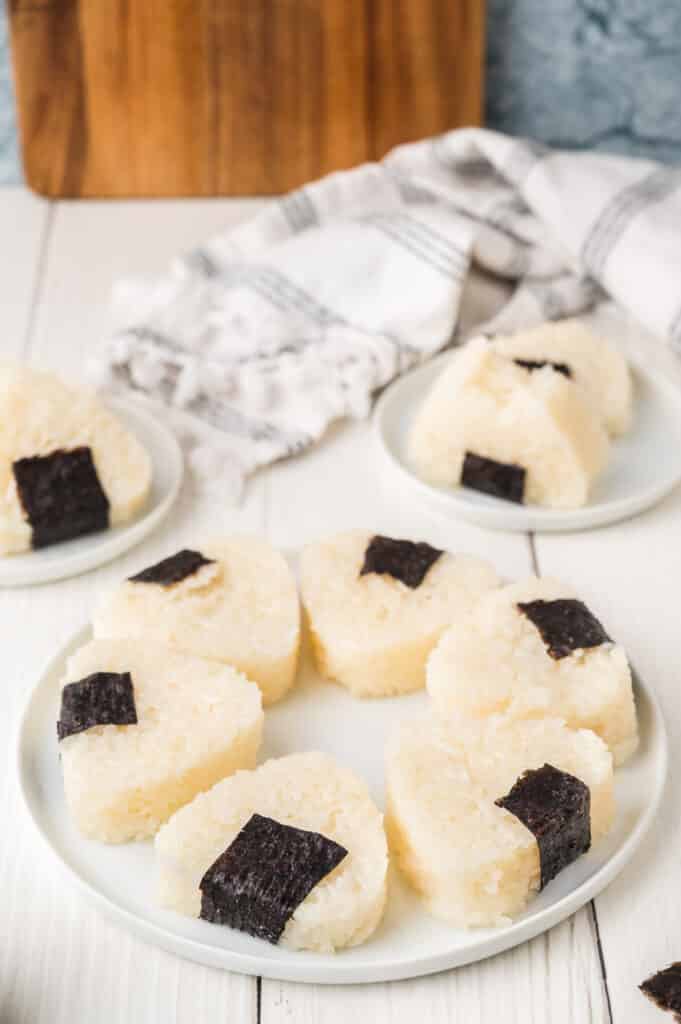 platter with onigiri in front of two smaller plates with onigiri on them