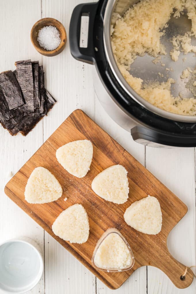 forming onigiri with mold next to instant pot