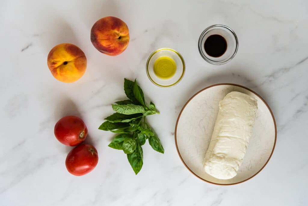 ingredients for peach caprese on marble counter
